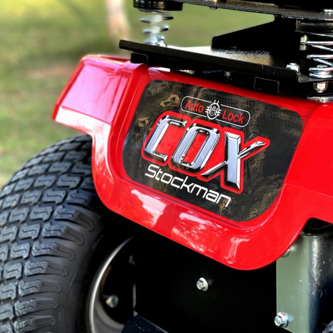 Close-up of a red and black lawn mower with 'Cox Stockman' branding.
