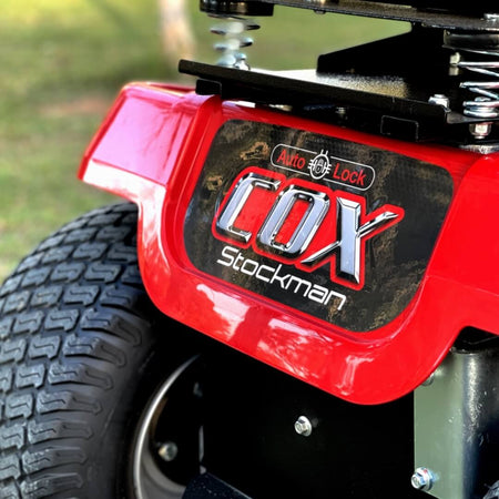 Close-up of a red and black lawn mower with 'Cox Stockman' branding.